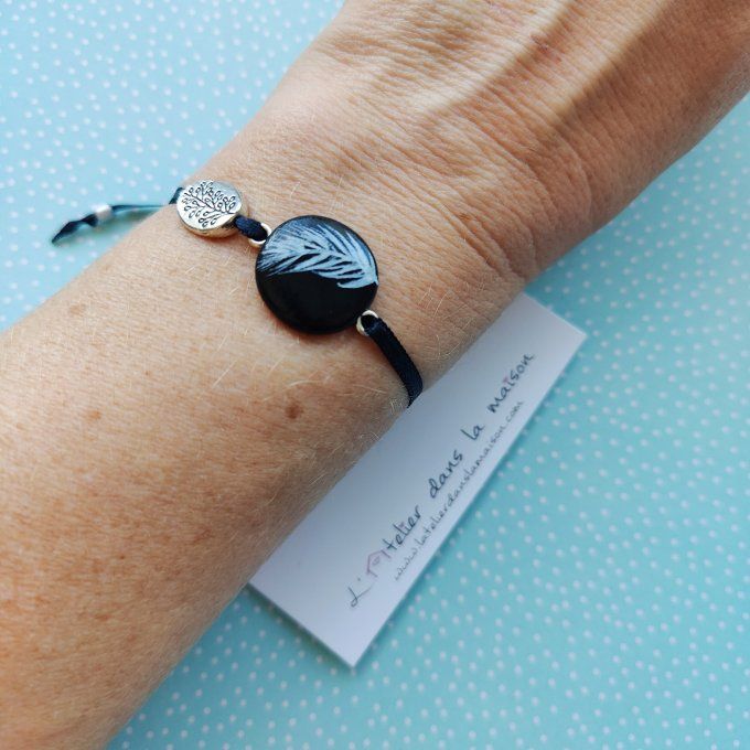 bracelet noir et plume blanche